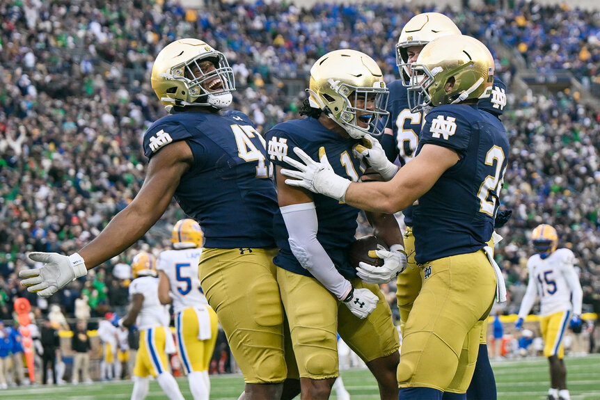 players on the Notre Dame Fighting Irish celebrate after a play on the football field