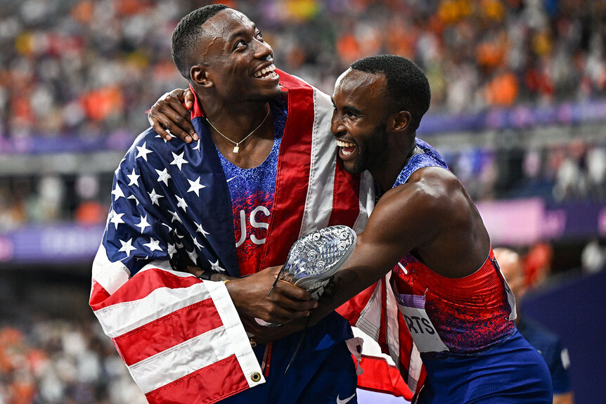 Grant Holloway and Daniel Roberts hugging after their race at the Paris 2024 Olympics.