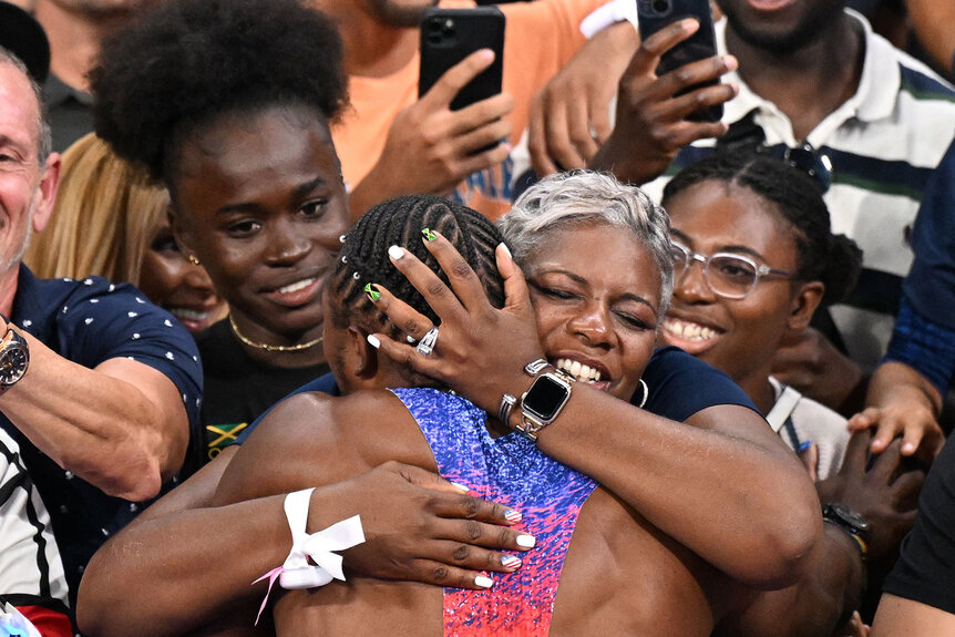 Noah Lyles hugs and celebrates with his mother after winning the men's 100m final