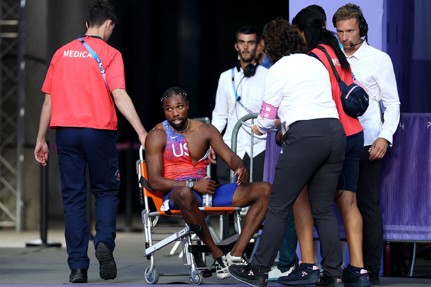 Bronze medalist Noah Lyles of Team United States is taken off from the track with a wheelchair after competing in the Men's 200m Final