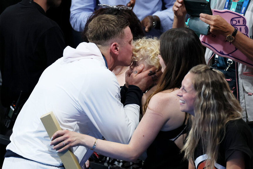 Adam Peaty kisses his child's forehead after the medal ceremony for the Men’s 100m Breaststroke Final on day two of the Olympic Games Paris 2024