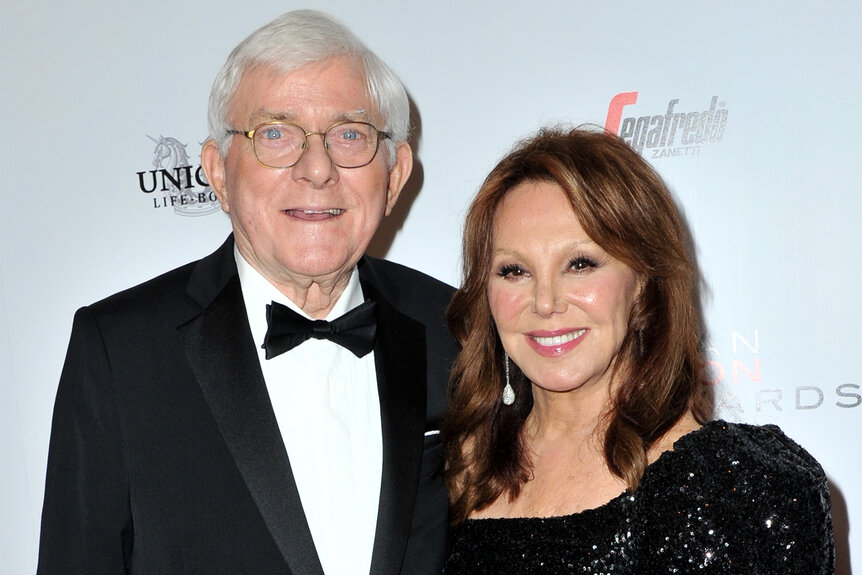 Phil Donahue and his wife Marlo Thomas pose together in a black dress and tuxedo