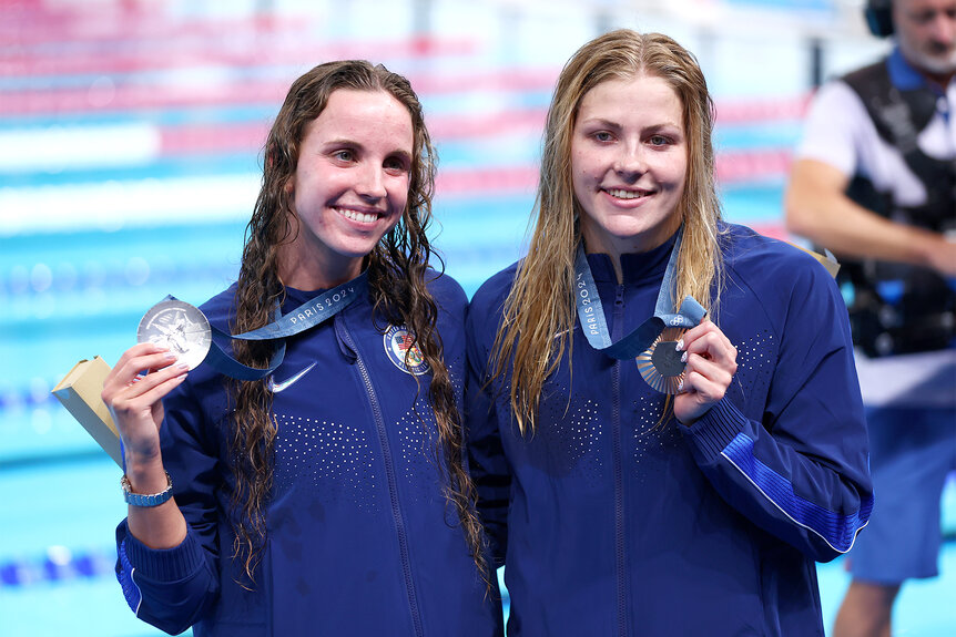 Regan Smith and Katharine Berkoff hold up their medals at the 2024 Olympics