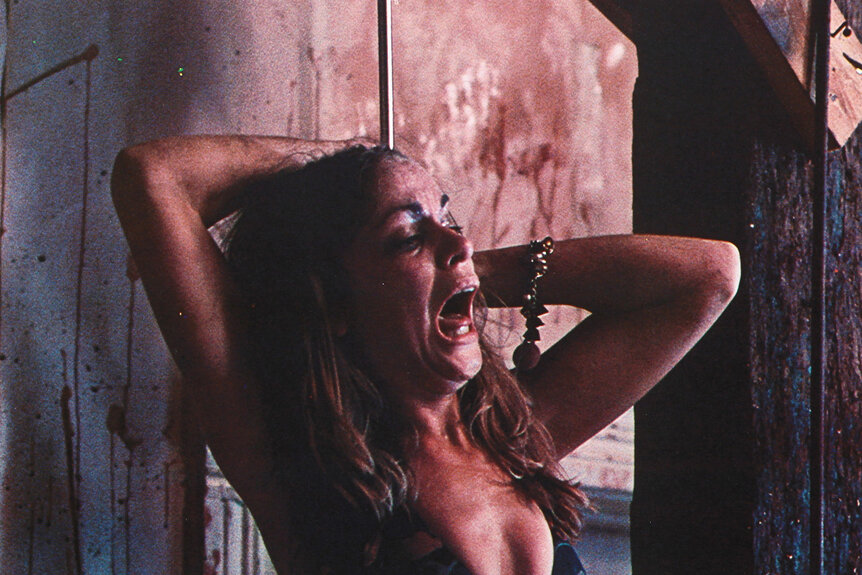 Teri McMinn screams and is chained to a pipe in a scene from The Texas Chainsaw Massacre