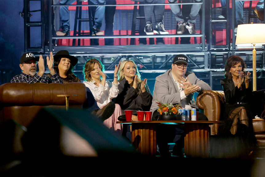 Toby Keith's wife and children sit on a couch together at a tribute to his life