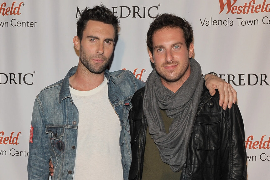 Adam Levine puts his arm over his brother, Michael Levine's shoulders