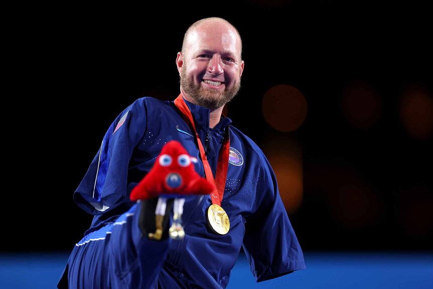 Matt Stutzman poses with his gold medal at the 2024 Paralympic Games.