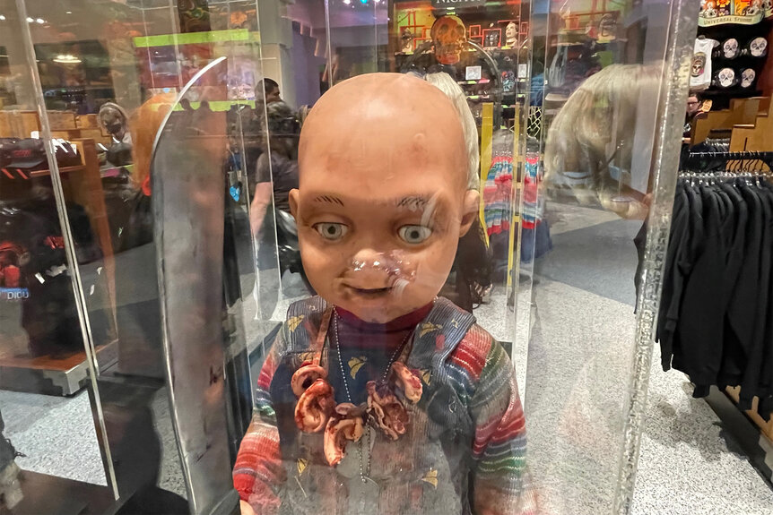 A doll from chucky in a glass case in the universal studio store