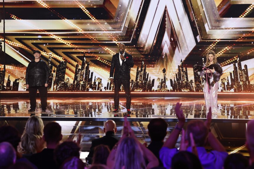 Richard Goodall, Terry Crews, and Roni Sagi & Rhythm stand onstage on America's Got Talent Episode 1920.5134 04987