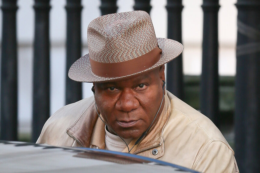 Ving Rhames wears a hat and tan jacket getting into a car in London