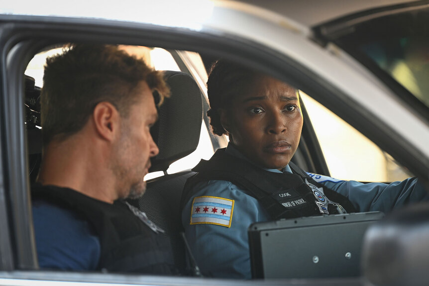 Officer Adam Ruzek (Patrick John Flueger) and Kiana Cook (Toya Turner) sit in their patrol car