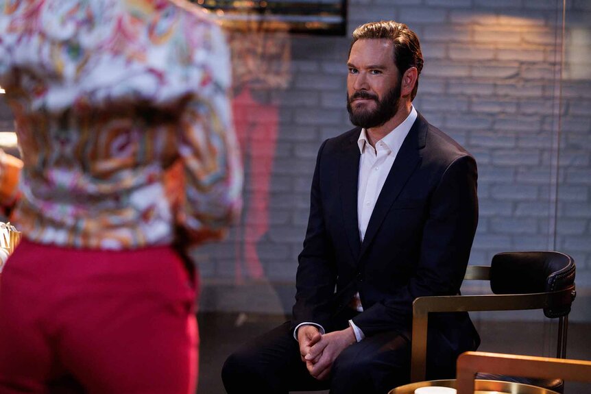 Sir (Mark-Paul Gosselaar) sits in front of a woman in Found Episode 205.