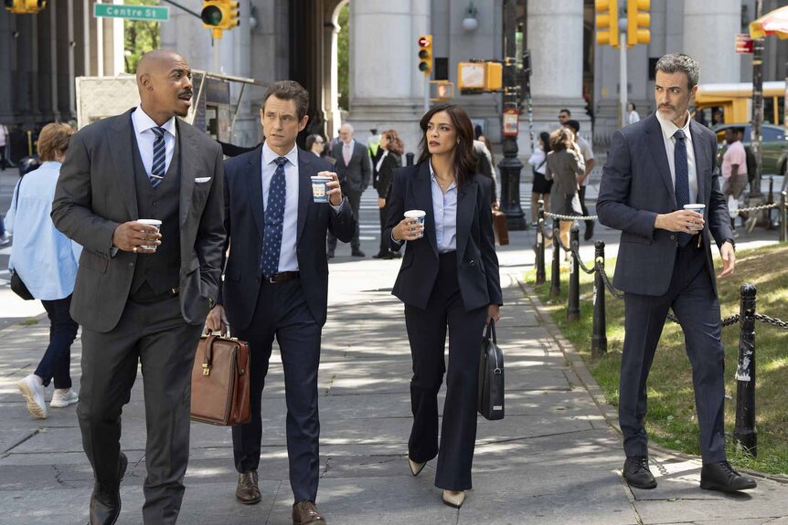 The cast of Law & Order walk outside with coffees in Episode 24005.