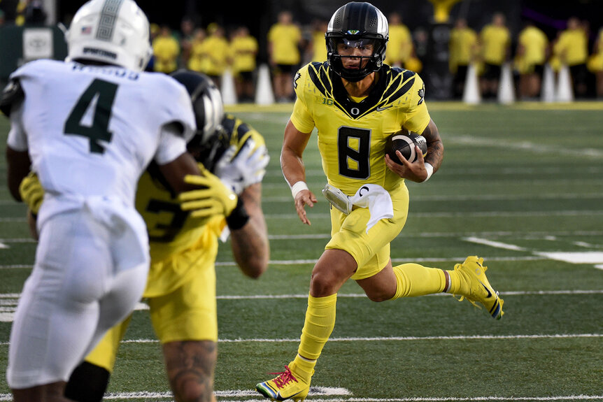 Quarterback Dillon Gabriel #8 of the Oregon Ducks runs the ball in for a touchdown