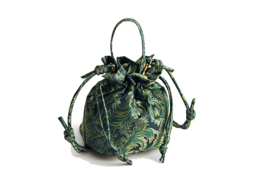 A drawstring purse that is green with yellow and black designs