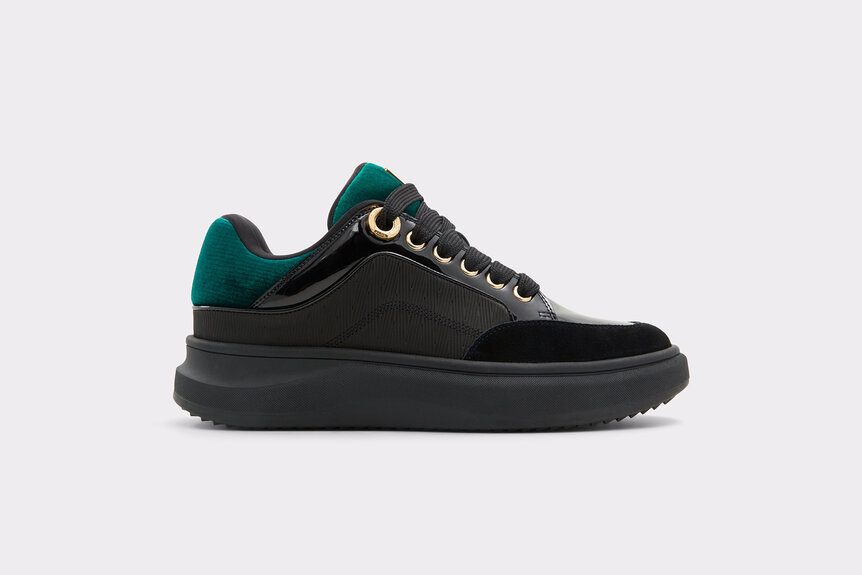 A black sneaker with green velvet and gold hardware