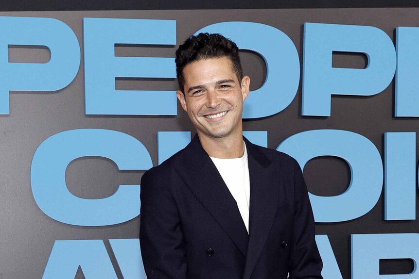 Wells Adams smiles in a navy blazer.