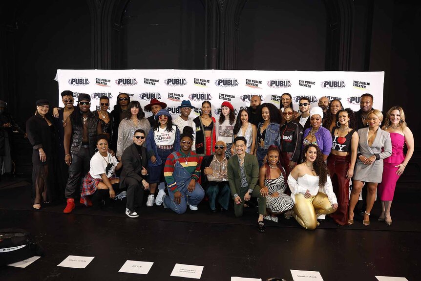 The cast of "Hell's Kitchen" pose together in front of a backdrop.