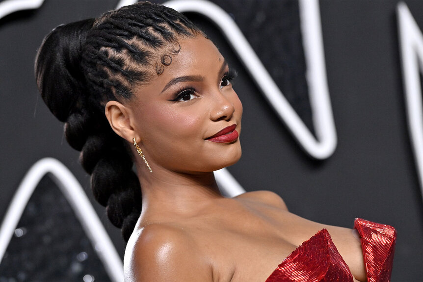 Halle Bailey posing in front of a step and repeat.