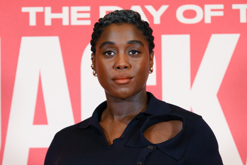 Lashana Lynch wears a black dress on the red carpet