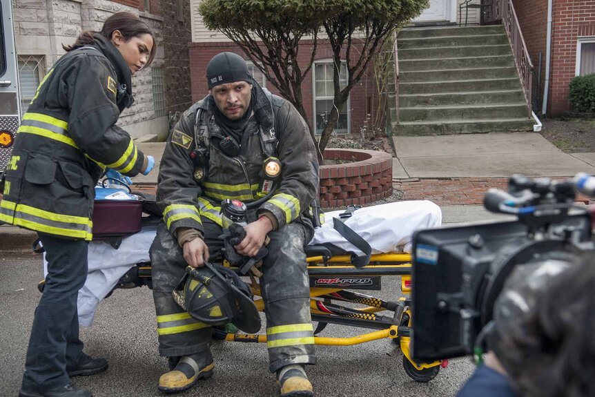 Gabriella Dawson (Monica Raymund) tends to Joe Cruz (Joe Minoso) who sits on a gurney on Chicago Fire Episode 116.