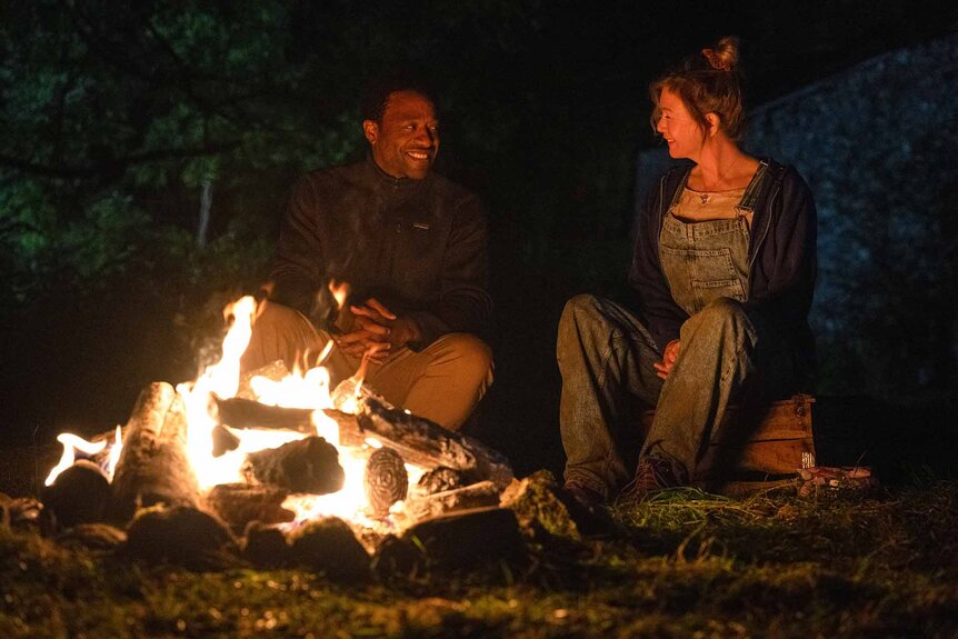 Mr. Walliker (Chiwetel Ejiofor) and Bridget Jones (Renée Zellweger) sit near a bonfire in Bridget Jones: Mad About the Boy (2025).