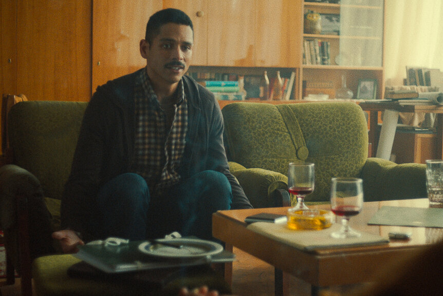 Charlie Barnett as Alan Zaveri sitting on a couch in Russian Doll