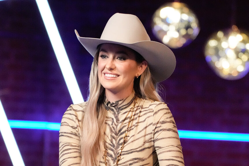 Lainey Wilson sits on a chair on the voice season 26 episode 16