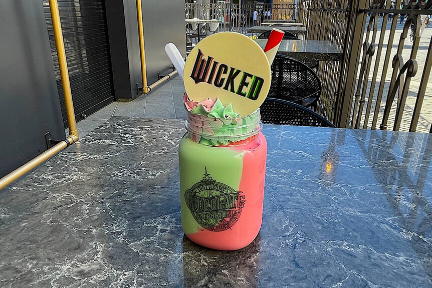 A green and pink milkshake with a wicked sign on it at Universal Studios Hollyood