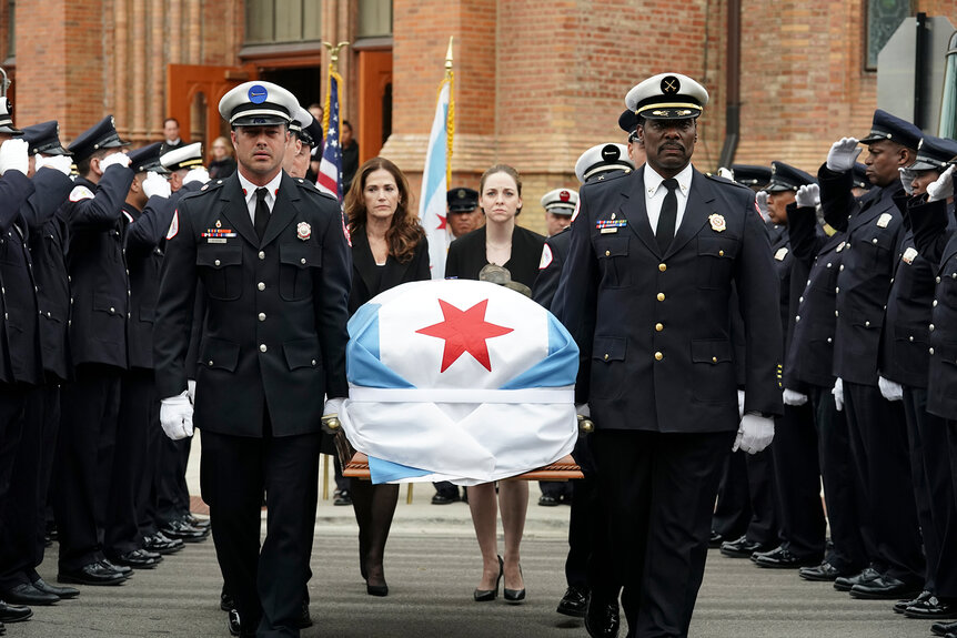 Kelly Severide and Wallace Boden hold a casket during a funeral procession on Chicago Fire Season 7 Episode 7