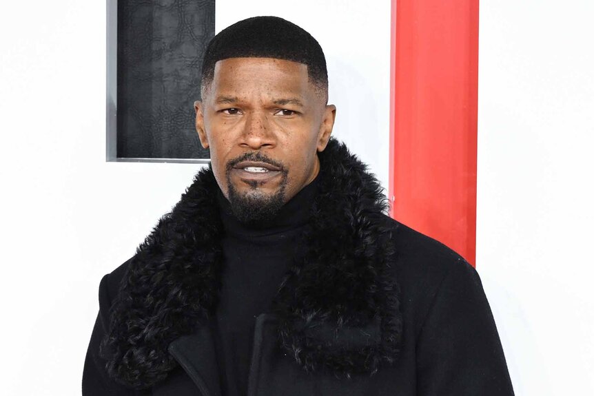 Jamie Foxx wears a fur trimmed black coat.