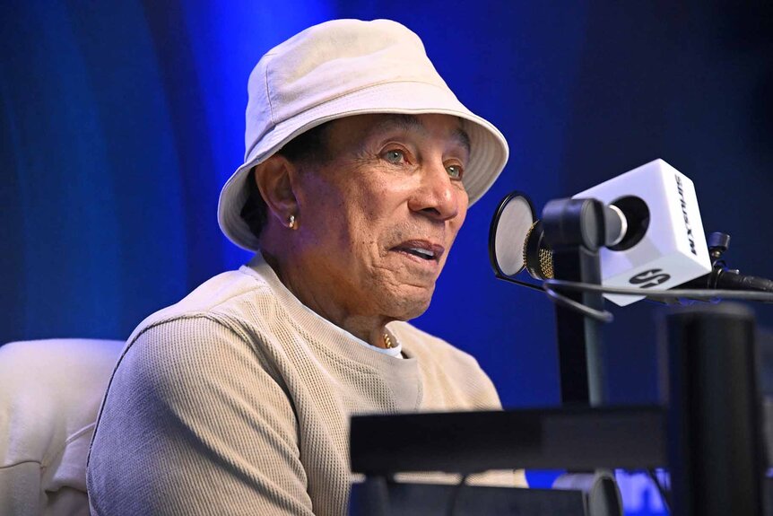 Smokey Robinson wears an off-white outfit during a radio interview.