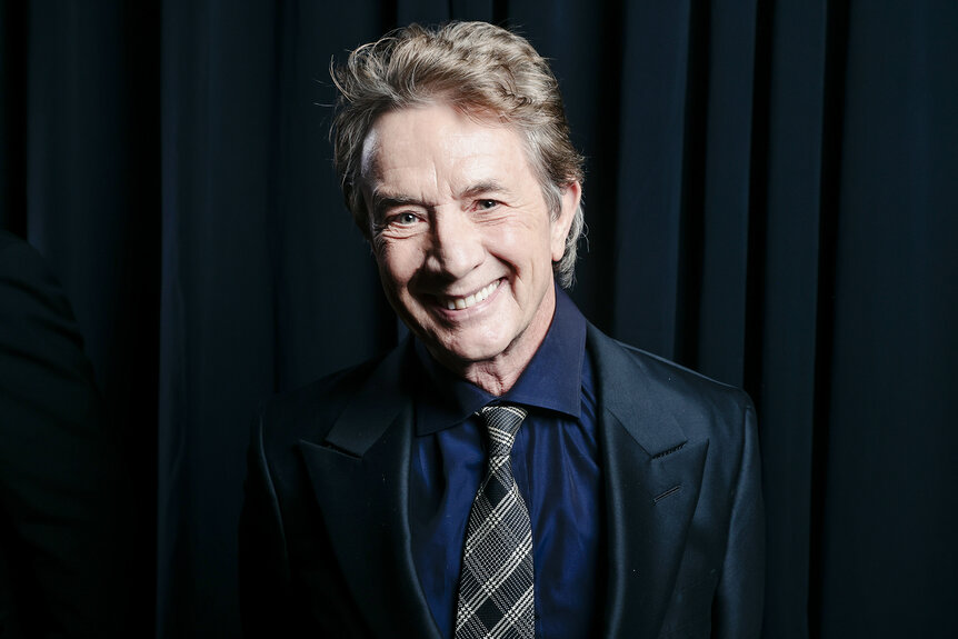 Martin Short smiles in a dark blue suit during an award ceremony