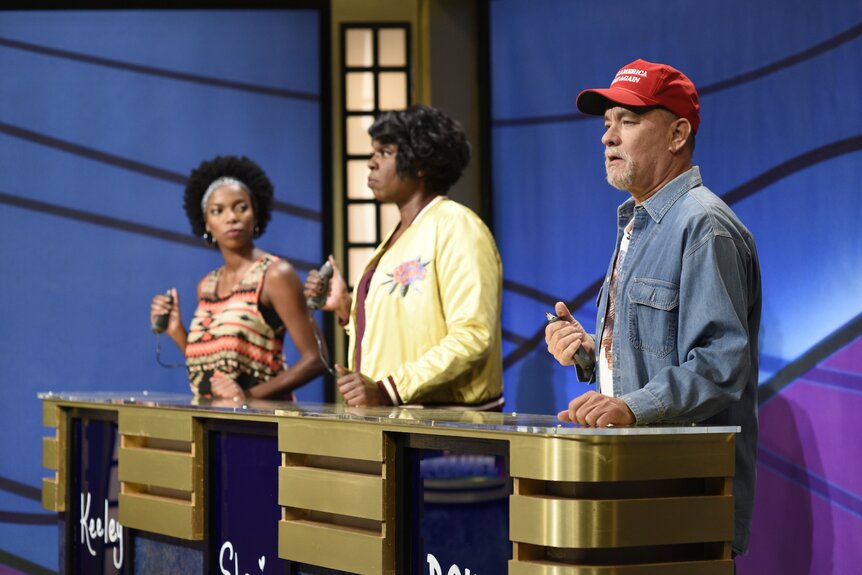 Keely (Sasheer Zamata), Shanice (Leslie Jones), and Doug (Tom Hanks) play Jeopardy on SNL Episode 1708.