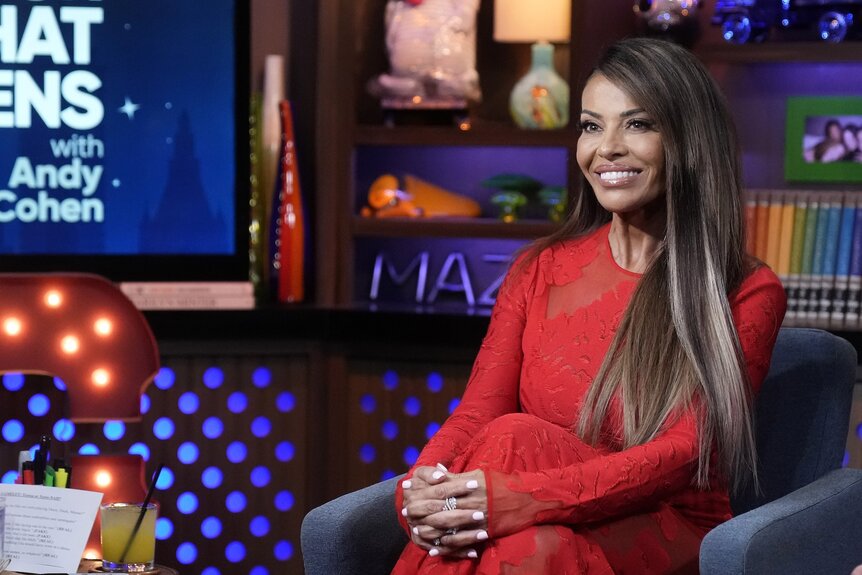 Dolores Catania smiles in a red dress.