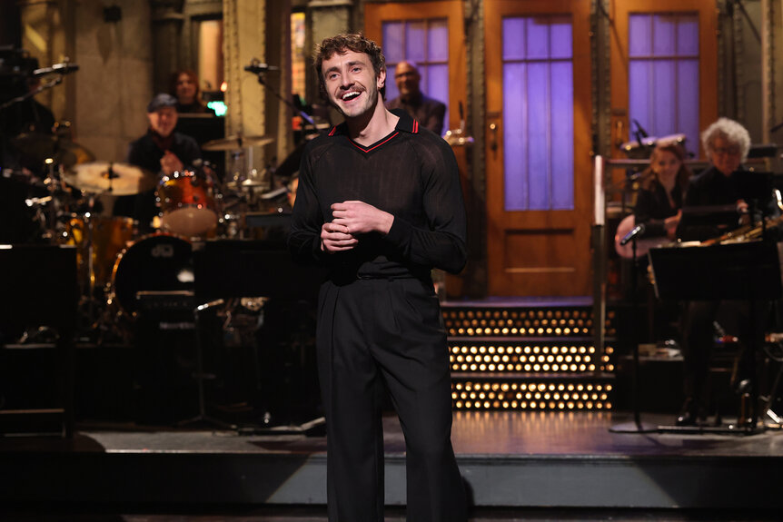 Paul Mescal stands on stage and laughs during the monologue on Saturday Night Live Season 50 Episode 8