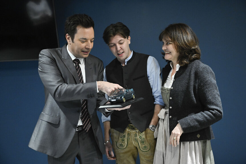 Jimmy Fallon talking and looking at a model car with the Ewerdwalbesloh family.