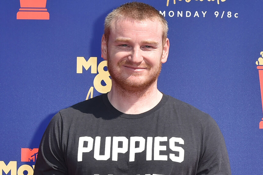 Wes Bergmann wears a black t shirt that says puppies to the Movie & TV Awards