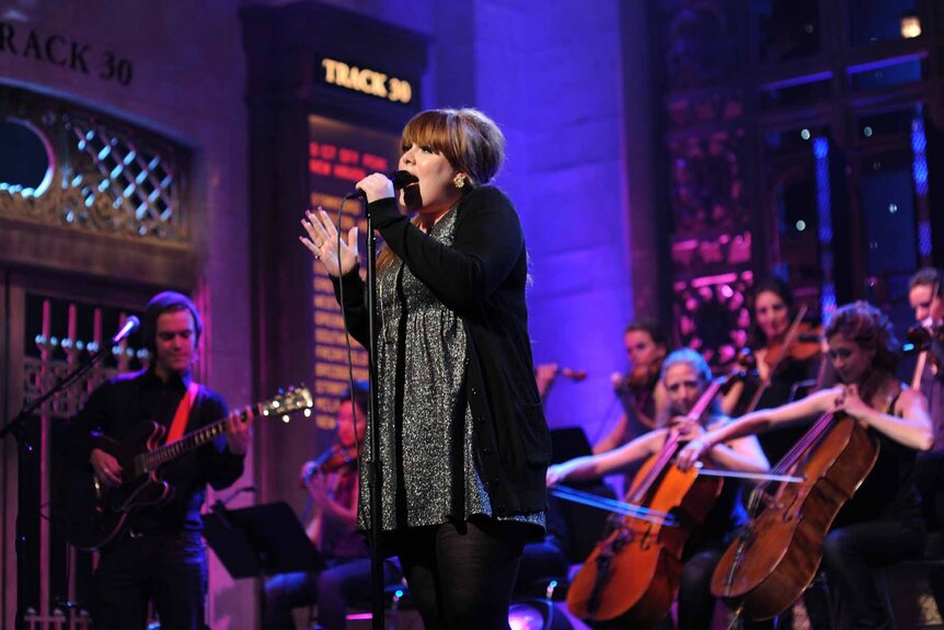 Adele performs onstage with an orchestra on Saturday Night Live Episode 1536.