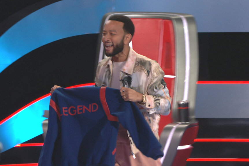 John Legend holds up a legend jacket on The Voice Season 23, Episode 3